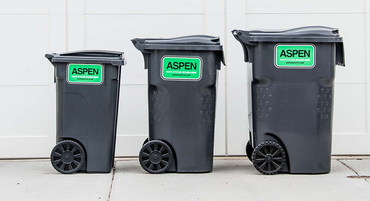 Three different sized trash cans lined up